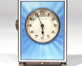 CARTIER MINIATURE REPEATING ENAMEL CLOCK  |  Quarter repeater The circular cream dial with gilt Arabic numerals and blue steel hands to the polished bezel and blue guilloche enamel case, with further cream enamel line border, raised on bun feet. Mechanical movement c.1920's. Signed Cartier to the dial and European Watch & Clock Company, Swiss,Sterling. Case number: 11993. 3in (76mm)
(267) N.B. Descriptions are revised from a 1994 insurance appraisal by a noted N.Y.C. auction house Horologist
