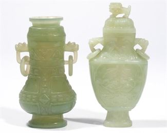 (2PC) CHINESE CARVED CELADON JADE VASES | 20th century, both with lidded with double ring handles and archaistic relief decoration, including one with a lion finial, both on wood stands
h. 8-1/4 in. (tallest)
