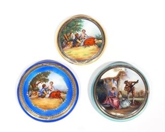 (3PC) ENAMELED SCENIC POWDER BOXES | Each with guilloche enamel scenes; Including a blue enameled box with a scene of an amorous couple beside a tree (dia. 2-1/2 in., marked "87"), a yellow enameled box with an identical scene, and a larger pale blue box with a scene of ladies and a lute player (2-1/4 in.)