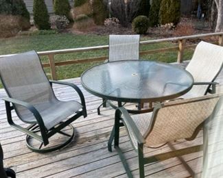 Patio set complete with 4 chairs and umbrella. Table has a glass top.
