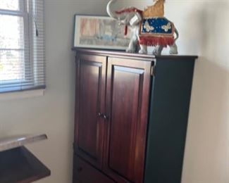 Tall armoire with exotic elephant statue on the top of it