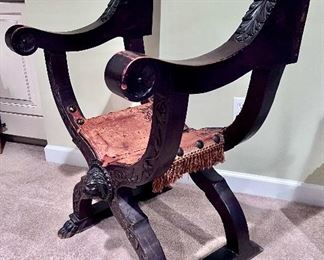 Antique saddle folding chair with lions head and hand carved accents