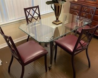 Scalloped glass top table with metal base and (4) metal chairs.                                  Table: 30”w 50” L 28.75” T.                                $150.00