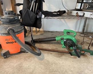 Garage:  A 10-gallon SHOP-VAC is to the left of a green HITACHI gas leaf blower and a green electric BLACK & DECKER shrub & edge trimmer.  Manuals for the blower and trimmer are with the cashier.  