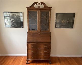 Bedroom #4:  Two black & white framed photographs flank a vintage secretary.  It has two adjustable shelves behind glass doors; a slant-front/drop-down desk which covers various cubbies; and three drawers.