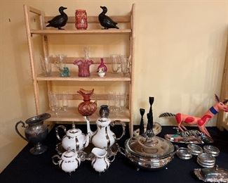 Family Room:  Clear glass Irish coffee mugs and fancy stemware surround cranberry glass and silver-plate, among other collectibles.  To the right are two Mexican wood animal carvings (one is by artist Eloy Pinos).