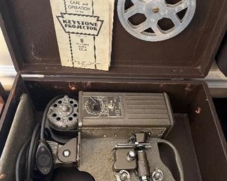 Dining Room:  The vintage "Steam Punk" Keystone 8mm Model CC -8 movie projector has its original case and manual.