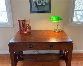 Bedroom #4:  A 1940's Arts & Crafts/Mission oak library table/desk is by the "Wolverine Mfg. Co." out of Detroit, Michigan (the label is still attached inside the drawer).  It has one dovetailed drawer and an under-shelf.  The hammered drawer pulls appear to be original.      The next photo shows the side of the library table/desk.                                                                                                The book of Arts & Crafts; "Poverty Sucks" poster; and the banker's lamp with green glass shade are also for sale.  The newer "Morris" rug measures approximately  5' x 7.'