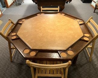 Lower Level:  A folding 52-1/2" poker table with beverage inserts is shown with one of a set of two separately priced four natural wood folding chairs.  The next photo shows the poker table with its included two-piece table cover in place.