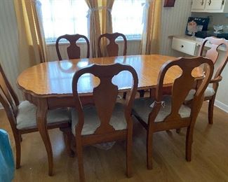 Like-new dining set with leaf and six chairs. Protective plastic cover on all chair cushions; protective mat for table.