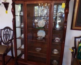 Vintage oak china cabinet with Griffins, framed art, cups & saucers, etc.