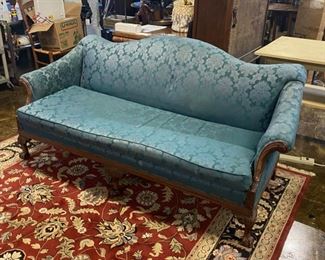 Early 1900's Mahogany Trimmed Camelback Sofa on Casters and with Rolled Arms