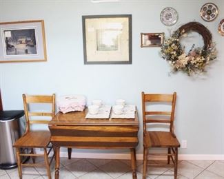 Drop leaf table shown with two antique chairs.