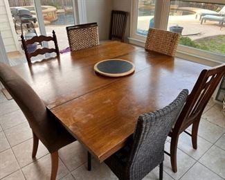 Square dining table with leaf and six mis-matched chairs in wicker, wood and fabric