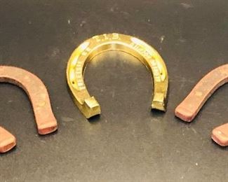 Brass horseshoe flanked by Daisy horseshoes