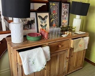 pine buffet from london with a variety of glassware, art, linens, and decor