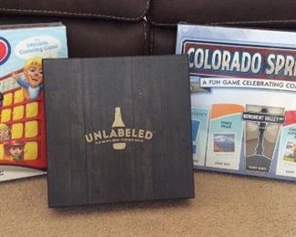 Games Including Colorado Springs-opoly (NEW), Unlabeled The Blind Beer Tasting Game, and Guess Who.