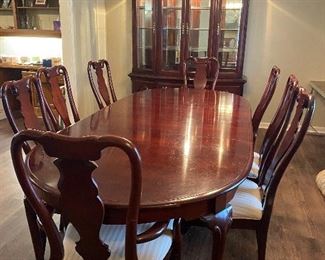 Cherry wood dining table and 8 chairs. Table has 2 removable leaves. 