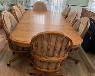 #59	Oak Rectangular Table w/2 leaves & 8 Heavy Wooden Chairs that slightly recline on Wheels w/Tan Padded seats & Back w/arms (arms on All Chairs) w/double pedistal Feet  70-103x48x29	 $375.00 
