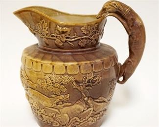 	ANTIQUE POTTERY HOUND HANDLED PITCHER, RELIEF HUNT SCENE OF DOGS, STAG & WILD BEAR, APPROXIMATELY 9 IN HIGH

