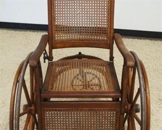 	VICTORIAN OAK CANE SEAT WHEEL CHAIR, WOOD WAGON WHEELS, PRESSED BACK DESIGN ON CREST W/BENTWOOD UNDERCARRIAGE
