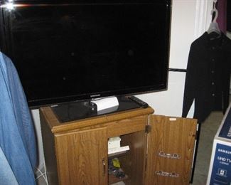 43 inch tv sitting on top or an Arrow Sewing machine and case