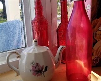 Red glass bottles and china tea pot