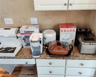Lots of small appliances-many new in the box .  Keurig, Ice cream maker, Cuisinart vertical waffle  maker, Deep fryer, rice cooker, copper electric frying pan more