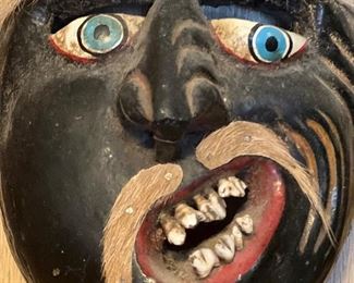Carved mask with animal fur and teeth