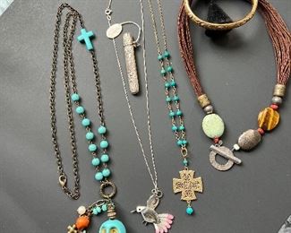 In this picture, you will see a fun skull necklace. The hummingbird next to it is a Zuni peace and has a sterling silver chain. The cross is so pretty, the last piece is from Silpada. It has a multi cord necklace that is leather, with brass, turquoise, Tigereye, howlite, pyrite, and coral!