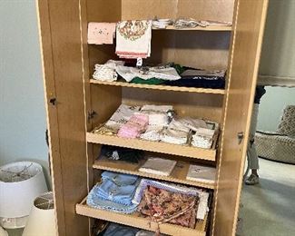 Storage cabinet (would be great for a garage or kitchen) full of linens. Napkins, dish towels, placemats etc