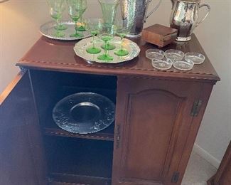 Tall cabinet; depression glass; forged aluminum pitcher and platter, silver-plated pitcher and trays; and cheese board