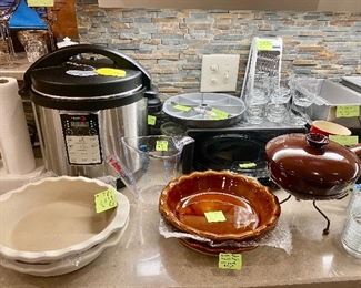 Qty 2 Pampered Chef vanilla stoneware pie plates, qty 2 Emile Henry brown pi plates, an 8 qt Instant Pot by Fagor