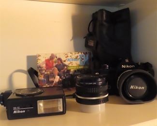 Nikon SLR camera with bag, flash unit and lens.