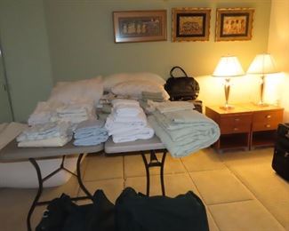 Bedroom area. Linens, blankets, luggage, towels.