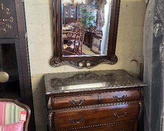 Marble-top chest with hanging mirror.