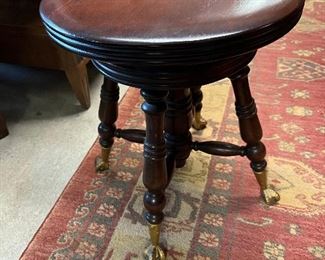 Piano stool with ball and claw feet.