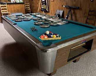 Professional billiard table with pool sticks on wall felt in great shape