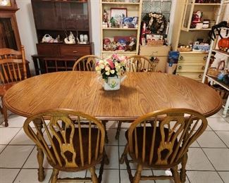 Country style 5-piece wood dining set including an oval table with leaf and four matching chairs.