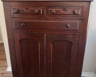 Professionally refinished antique pie safe repurposed as storage cabinet.