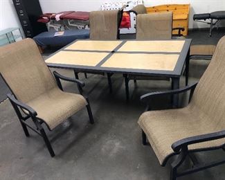 Hampton Bay patio set - table + 4 chairs. Table is painted aluminum with tile inset & hole for umbrella (table : 40” x 70” x 27.5”H) Tiles lift out for moving & transport - table is light with tiles removed. 