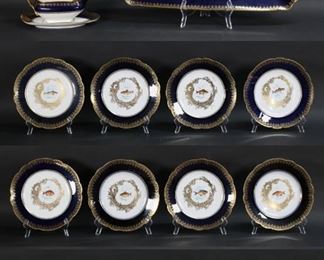 19	15 Piece Delinieres Limoges Porcelain Fish Set	15 piece Limoges porcelain fish set. Platter, 12 plates, sauce boat and underplate. Hand painted fish motif with cobalt and gilt rims. D & C. France and R. Delinieres & Cie. Limoges marks to the undersides. Plates each 9"-diameter, platter 24"L. Losses to gilt decoration on rims.
