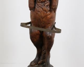 51	Black Forest Carved Dog Umbrella and Cane Stand	"Black Forest carved dog umbrella and cane stand. 19th century. Carved wooden dog standing on hind legs, brass holder for canes and umbrellas, removable metal drain tray. Chips,  scratches and losses to wood throughout base of stand. Wear and losses to wood on left and right sides of dog against brass holder. Split to wood on left side of dog's face through eye. Small nicks and scratches to wood on body and face of dog. Chip to wood on dog's left bottom tooth. Splits to wood on base of stand. Screw  missing from brass holder support on back of dog. From the collection of a prominent Connecticut family.
11 3/8"" W x 12"" D x 44 1/8"" H"
