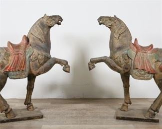 72	Pair of Chinese Tang Style Polychrome Horses	"Pair of Chinese Tang style polychrome horses. 20th century. Carved wood and composition with polychromatic design, each horse raising one leg up. Wear and debris throughout surface and patina of both horses. Small chips and losses to wood on edges of bases of both horses. Splits and cracks to wood on legs of both horses. Repair to front left raised leg of one horse.  

47"" W x 13"" D x 46"" H. One horse is an inch and a half shorter than the other in width measuring at 45 1/2"".

Provenance: Christie's Interiors, Lot 776, July 17th, 2012. From the collection of a prominent Connecticut family."
