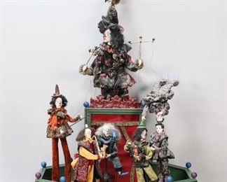 77	Jean-Pierre Camus Musical Automaton Puppet Band	Jean-Pierre Camus French musical automaton clown marionette band. 19 1/4" x 13 1/4" x 35"H. Partially working condition, some pieces slow or loose. Chips and losses to fingers, crack to leg of puppeteer, chips to base, hair partially detached on figure on unicycle, pieces loose throughout. From the collection of a prominent Connecticut family.
