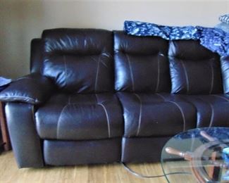 Overstuffed leather sectional sofa with a recliner at each end
