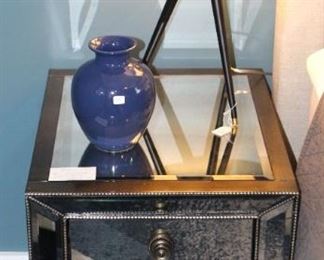 We have a pair of mirrored nightstands and tripod lamps.