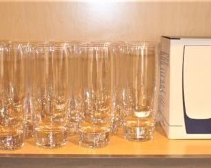 Shelf is full of Luigi Bormioli beverage glasses.