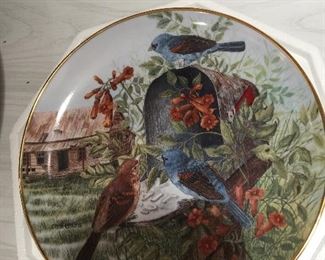 Birds enjoy honeysuckle flowers around an old rural mailbox on this porcelain plate with gold rim. 