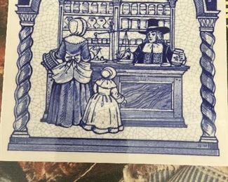 A Delft-like tile depicts and old-time pharmacy scene. 